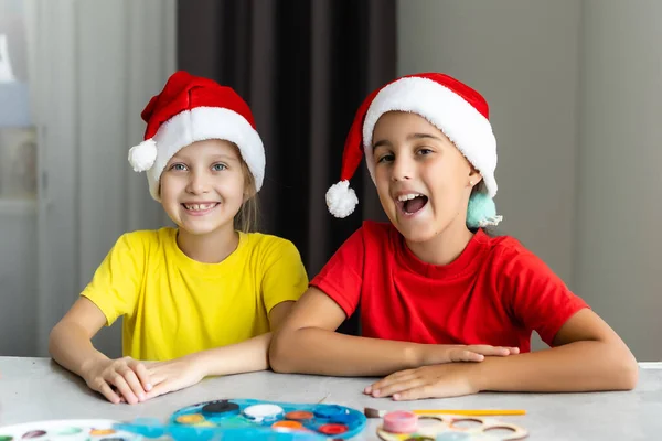 İki küçük kız kardeş Noel 'de evde el sanatları yaparken eğleniyorlar. — Stok fotoğraf