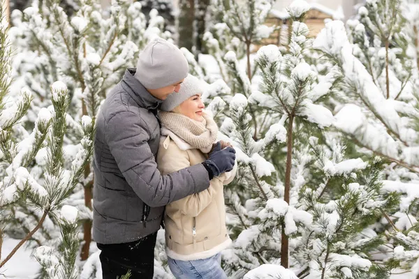 雪の冬の森を歩いて一緒にクリスマス休暇を過ごす幸せなカップル。屋外の季節活動。ライフスタイル — ストック写真