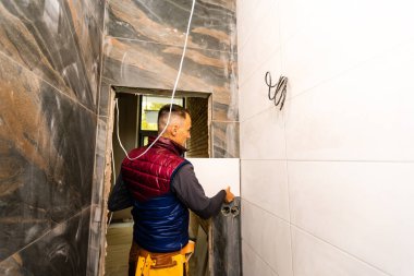 Seramik Karo döşeme. Seramik duvar karosu bulunduğu yapıştırıcı yerleştirerek kiremitçi