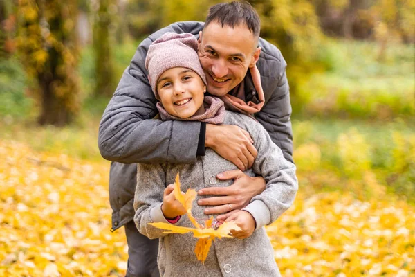 Mutlu baba-kız sonbahar parkında sarı yaprakların üzerinde — Stok fotoğraf