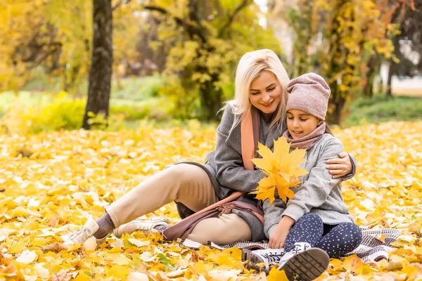 母亲和女儿之间飘落的树叶秋天公园里有乐趣. — 图库照片