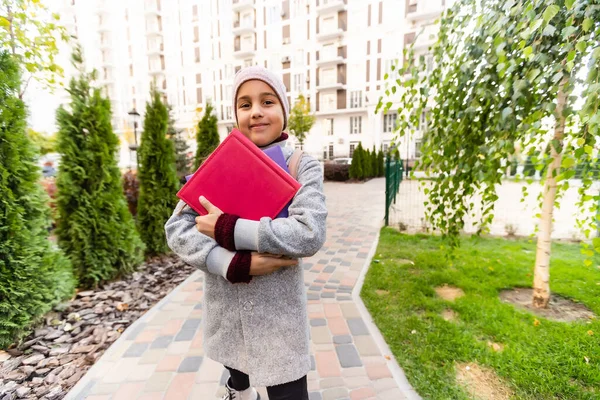 Uma colegial com mochila. Feliz infância. Início do ano académico. Hora de Outono para estudar. A estudar na escola primária. Conceito de educação escolar. Voltar a estudar — Fotografia de Stock