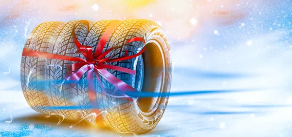 색색 배경에 빨간 리본으로 묶여 있는 자동차 타이어 — 스톡 사진