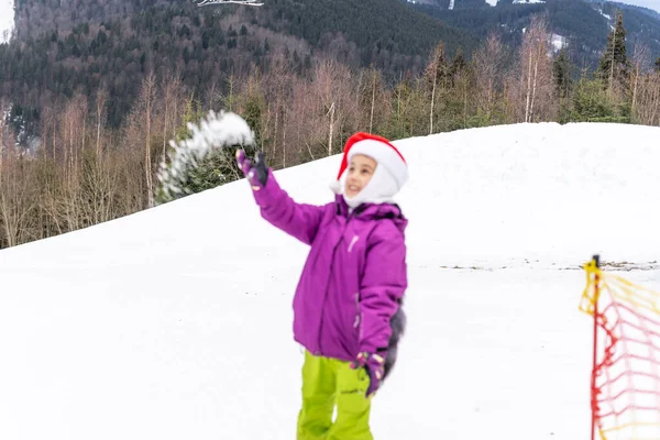 Κοριτσάκι στο καπέλο santa με snowboard στο χειμερινό θέρετρο — Φωτογραφία Αρχείου