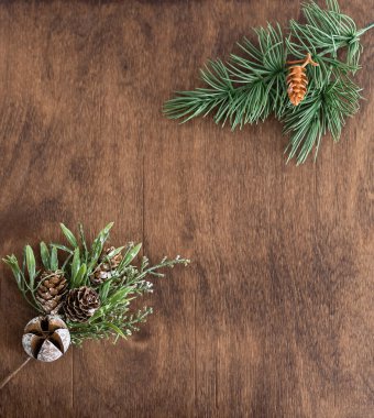 Ahşap zemin üzerinde yeşil ladin dalları ve koniler.