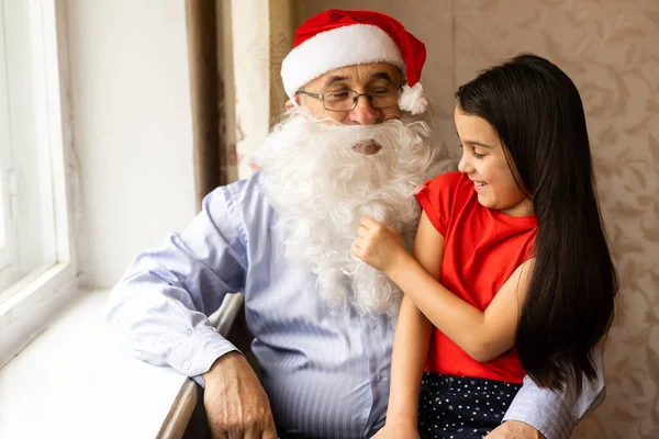 Noel Baba şapkalı yaşlı bir adam ve bir torun. — Stok fotoğraf