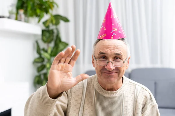 Retrato de homem idoso feliz em um boné de festa — Fotografia de Stock