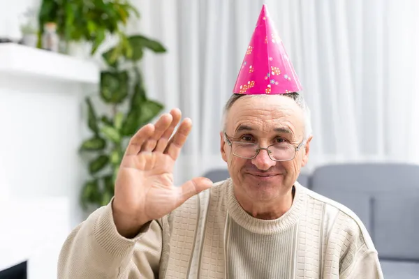 Portrait of happy elderly man in a party cap Stock Image