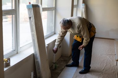 İş yerindeki tesisatçı. Su ısıtma radyatörü kuruluyor