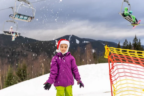Kislány télapó kalap snowboard télen üdülőhely — Stock Fotó