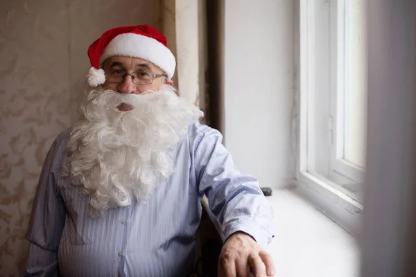 Portrait d'un homme âgé en chapeau de Père Noël regardant la caméra — Photo