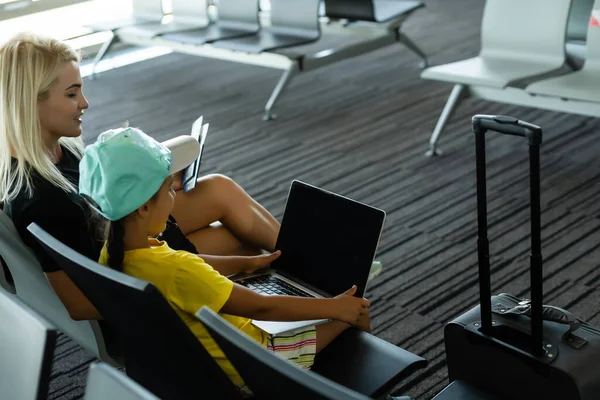 Familia en el aeropuerto. Atractiva mujer joven y linda hija pequeña están listos para viajar. Concepto de familia feliz. — Foto de Stock