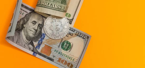 Bitcoins dorés et argentés et billets de cent dollars sur bureau en bois — Photo