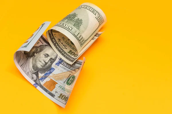 Single Hundred Dollar Bill Curled on yellow — Stock Photo, Image