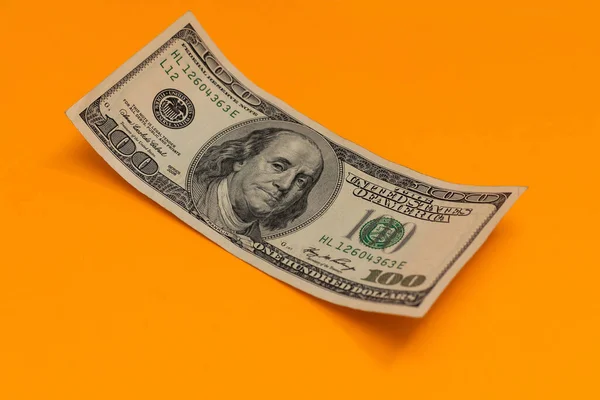 Notas de cem dólares isoladas sobre fundo amarelo — Fotografia de Stock