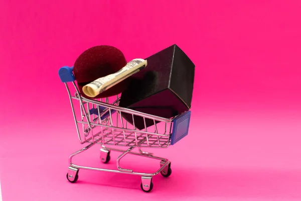 Χριστουγεννιάτικα δώρα και ψώνια σε τρόλεϊ απομονώνονται σε ροζ φόντο. — Φωτογραφία Αρχείου