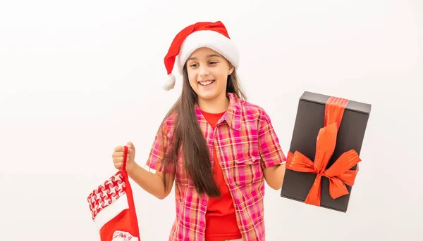 Linda niña sonriente en un vestido rojo comprobando su media de Navidad —  Fotos de Stock
