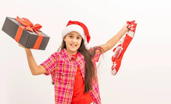 Cute smiling toddler girl in a red dress checking her Christmas stocking — Stock Photo, Image