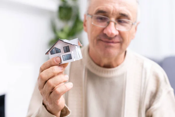 Starší starší muž s modelem domu — Stock fotografie