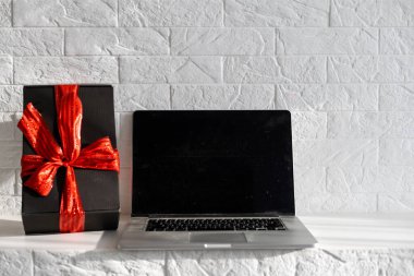 Noel alışverişi. Ekranda kopya alanı olan dizüstü bilgisayar, mevcut kutuların üzerinde duruyordu. Kış tatilinde internet ticareti