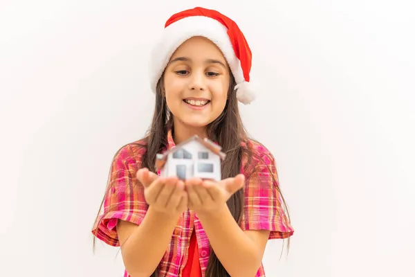 Маленька дівчинка тримає маленьку модель будинку в Різдво . — стокове фото
