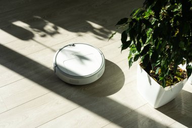 Robot elektrikli süpürge daireyi belli bir zamanda otomatik olarak temizliyor. Akıllı ev