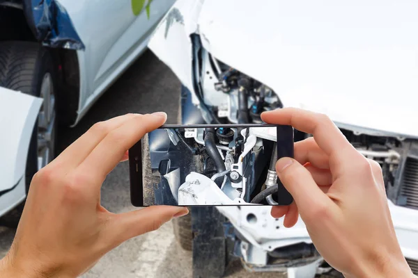 Hombre fotografiando su vehículo con daños para el seguro de accidentes con teléfono inteligente — Foto de Stock