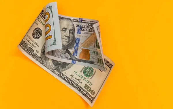 Single Hundred Dollar Bill Curled on yellow — Stock Photo, Image