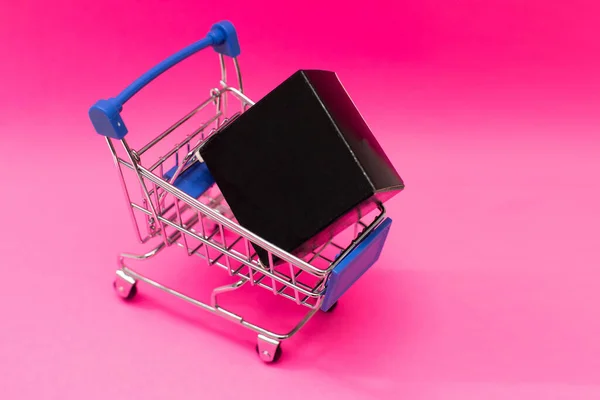 Christmas gifts and shopping in trolley isolated on pink background. — Stock Photo, Image