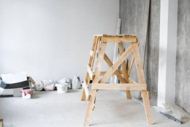 Apartmanda tamirat var. Duvarları yeni boyanmış parlak bir odanın içinde keçi boyacıları inşa ediyorlar. İnşaat evindeki beyaz duvarlar.