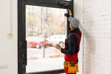 Adam yeni bir evde tornavida ile kilitleri sabitleme