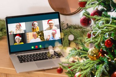 Sanal Noel partisi. Video konferansında genç bir adamın ev ofisteki bilgisayarla görüntülü konuşma yapması Online takım hediye konferansı..