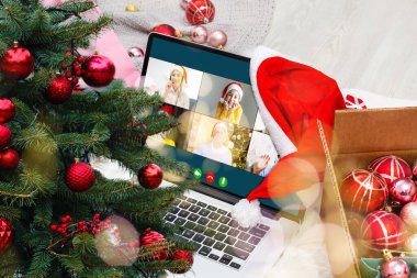 Atölyesindeki dizüstü bilgisayarında çeşitli mutlu çocukların olduğu bir video görüşmesi. Ev kavramında kişisel izolasyon ve sanal online kutlama. Noel