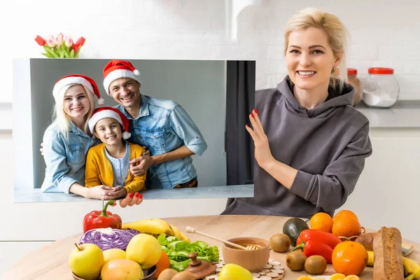 Photo printed on canvas, white background. Happy young family in Santa hats celebrating Christmas at home