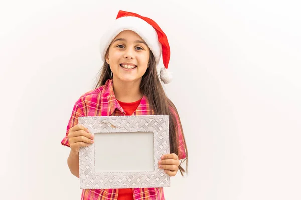 Усміхнена дівчинка з різдвяним капелюхом тримає білу рамку банера ізольовано . — стокове фото