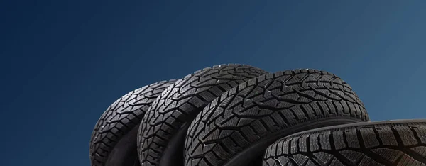 Winter car tires. Group of tires for winter driving on a blue background. — Stock Photo, Image