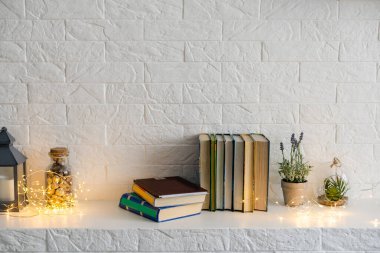 Şöminenin yanında gerdanlı bir kitap var.