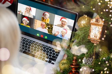 Atölyesindeki dizüstü bilgisayarında çeşitli mutlu çocukların olduğu bir video görüşmesi. Ev kavramında kişisel izolasyon ve sanal online kutlama. Noel