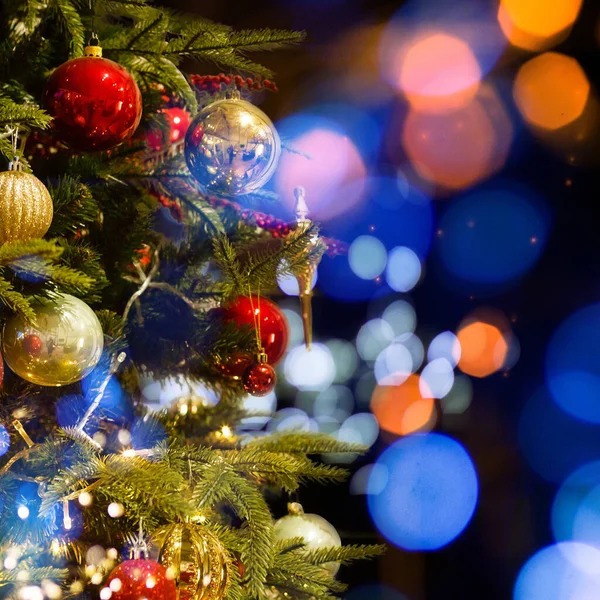 Closeup of red bauble hanging from a decorated Christmas tree — Stock Photo, Image