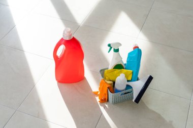 Temizlik servisi. Kova dolusu sünger, kimyasal şişeler ve paspas çubuğu. Lastik eldivenler. Ev aletleri.