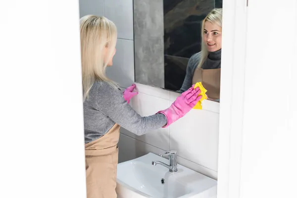 Close-up van vrouw schoonmaken van de spiegel in de badkamer — Stockfoto