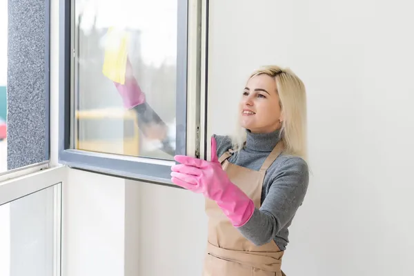 Mujer joven ventana de limpieza en casa después de la renovación —  Fotos de Stock