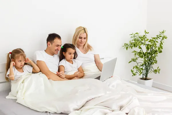 Ung familj vila tillsammans i föräldrar sängen — Stockfoto