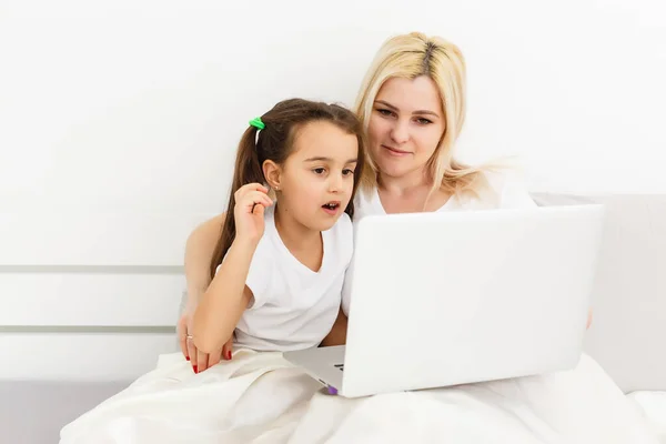 Giovane madre con bambino che lavora al computer da casa a letto — Foto Stock