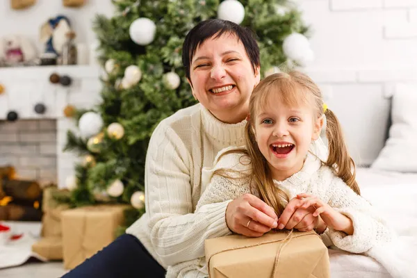 Anne ve kızı mevcut yerde oturma odasında yatan unwrapping — Stok fotoğraf