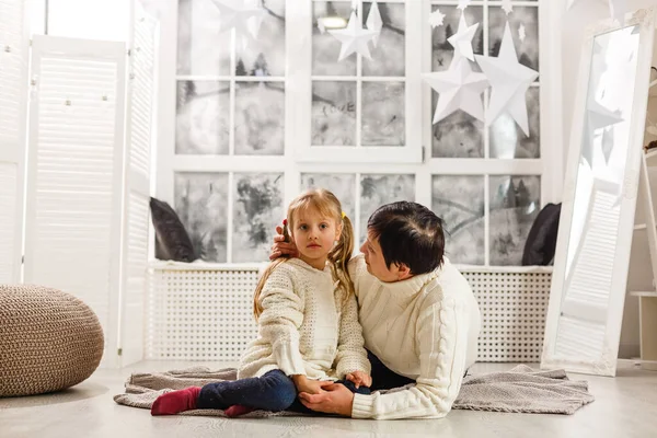 Madre e hija desenvolviendo un regalo tirado en el suelo en la sala de estar — Foto de Stock