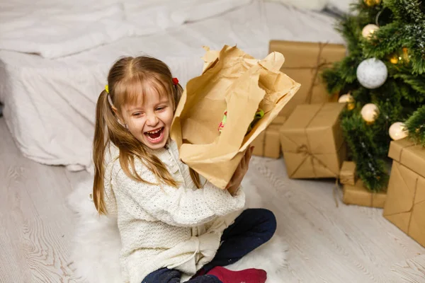 Gelukkig klein lachend meisje met kerst geschenkdoos. — Stockfoto