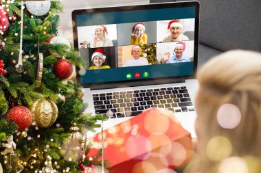 Atölyesindeki dizüstü bilgisayarında çeşitli mutlu çocukların olduğu bir video görüşmesi. Ev kavramında kişisel izolasyon ve sanal online kutlama. Noel
