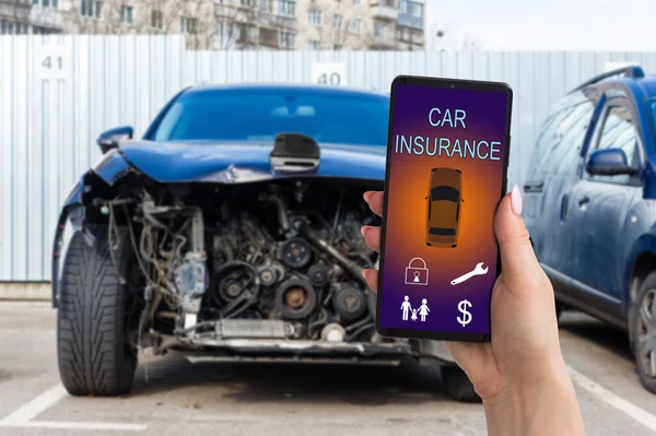 壊れた車の後にオンラインで自動車保険のアプリケーションを使用するためにスマートフォンを保持ハンサムな男の手。保険の概念. — ストック写真