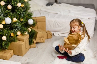 Mutlu, küçük, gülümseyen kız Noel hediyesi kutusuyla.